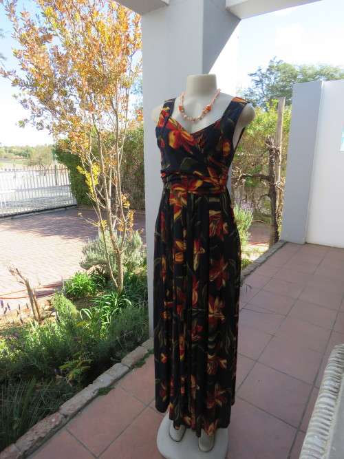 Black maxi dress with pleated skirt with bold orange/yellow flower pattern.Size 36/12.Good cond.