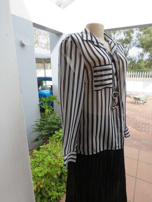 Sassy black and white vertically striped sheer polyester top.By 'MOSAIC' in size 36/12.As new.
