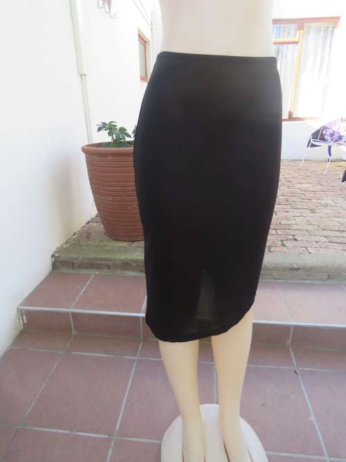 Trendsetting black stretch polyester skirt with high/low seam in 34/10.In good condition.