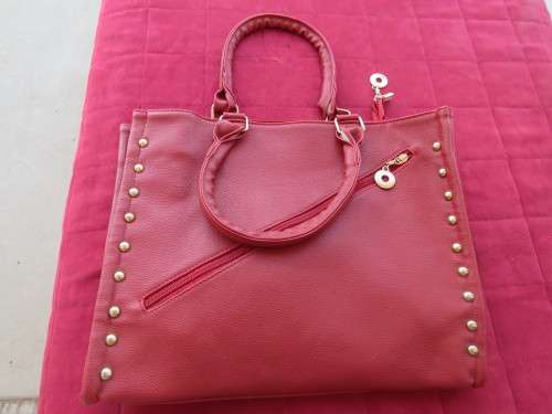 Large red handbag with studs.Size 35x29cm.Long extra strap included.Close with zip.New cond.