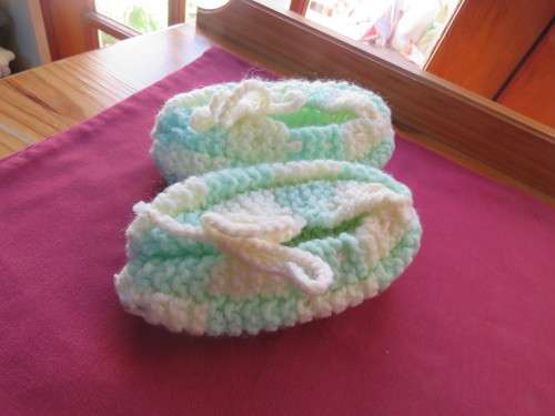 Pair of knitted slippers for girl in mint green and beige,will fit 5 to 7 yr old.Good condition.
