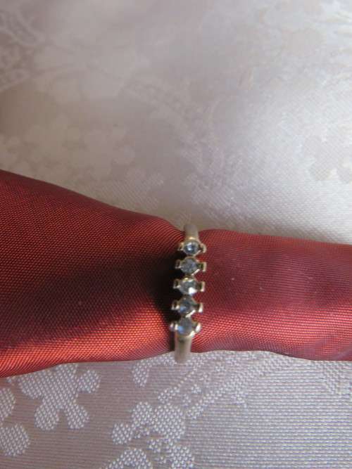 Dainty gold toned ring in size 8 with 5 simulated diamond stones.New ring.