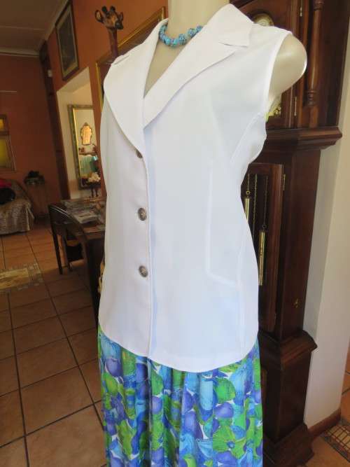 White tailored sleeveless jacket by 'TOPICS' in 40/16.In 100% wash and wear polyester.New cond.