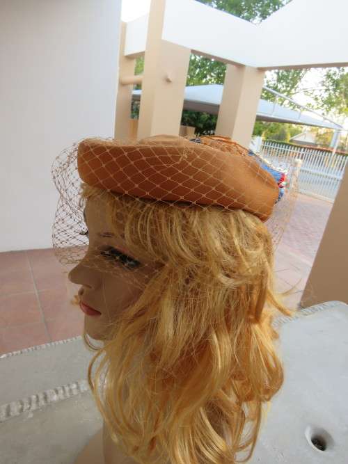 Caramel colour pillbox style fascinator with organza flower and netting.Good condition.