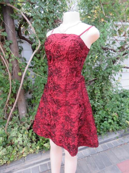 Evening dress in dark red with thin adjustable straps.Size 34/10 in satin.Fully lined.New condition.
