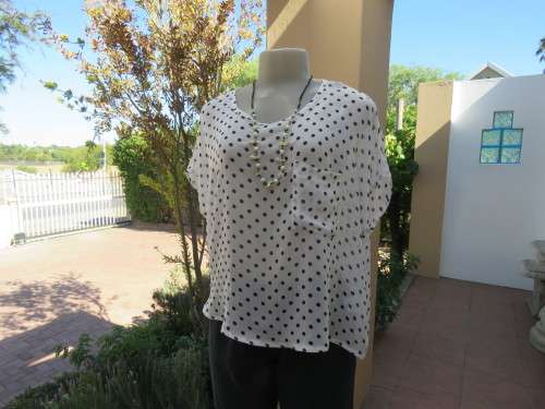 Pretty loose white throw-over top with black polkadots.By 'GRAIL' in size 40/16.New condition.