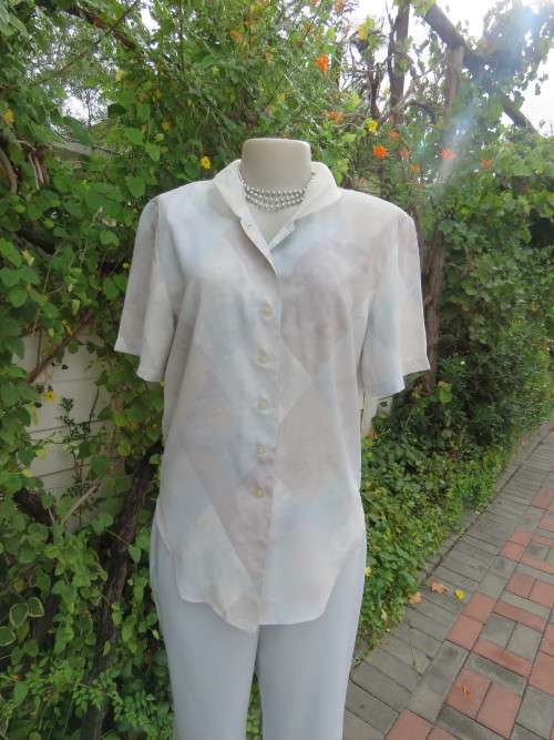 Smart blue patterned short sleeve top with voile collar. Size 34/10.In 100% polyester.New condition.