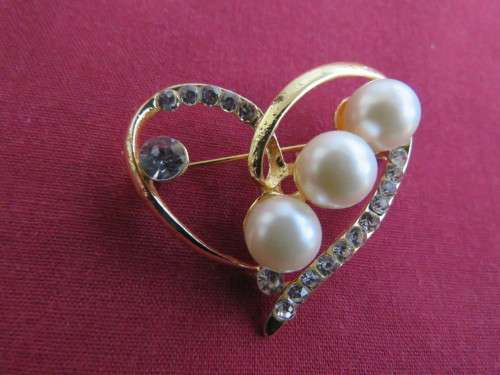 Gold toned heart brooch with 3 faux pearl stones and small faux diamond stones.New.