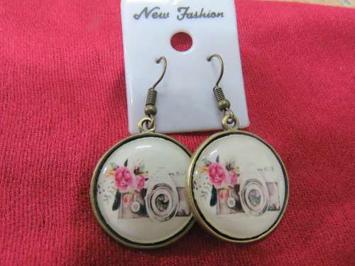 Pair of pierced drop earrings with porcelain vintage fronts in round design with brass backing.New.