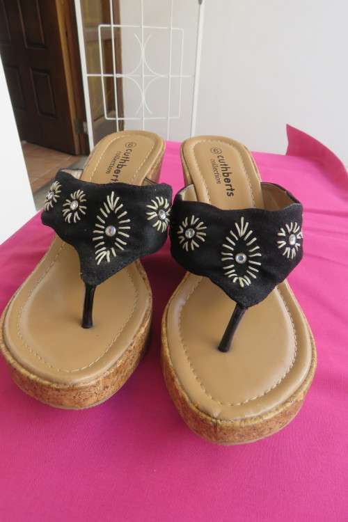 Pair of wedge heel sandals.Slip on style. Black band with embroidery and stones. Cork heels, Size 6