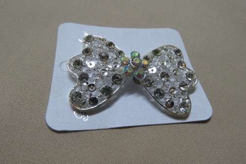 Fabulous silver toned brooch in bow design with Faux diamond stones. Size 5.5x4 cm. New.