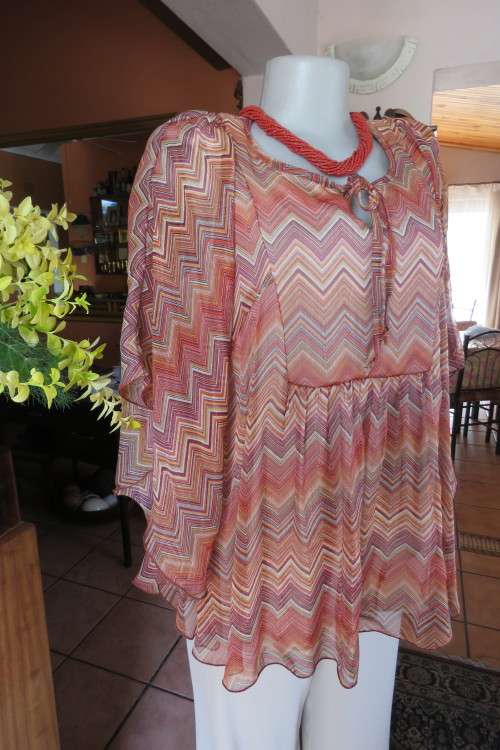 Stunning cream sleeveless polyester top with overlay in zig-zag autumn colours. Size 40/16.