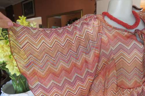 Stunning cream sleeveless polyester top with overlay in zig-zag autumn colours. Size 40/16.