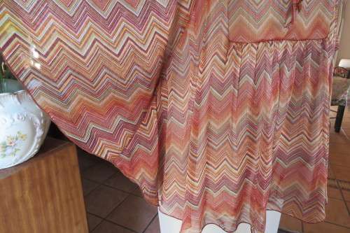 Stunning cream sleeveless polyester top with overlay in zig-zag autumn colours. Size 40/16.
