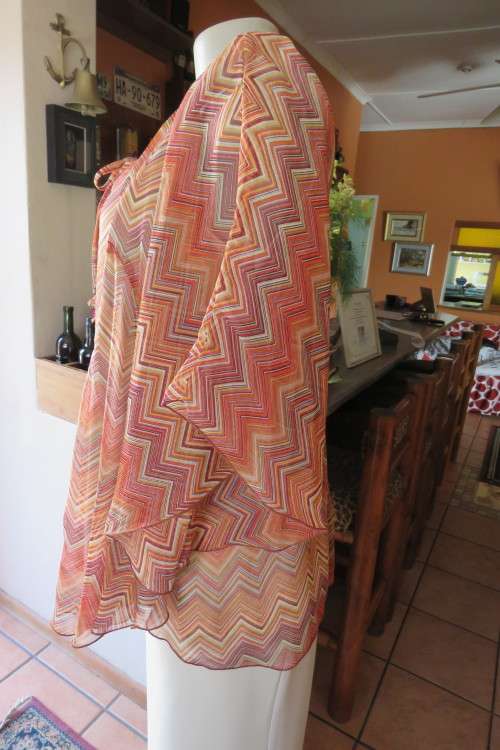 Stunning cream sleeveless polyester top with overlay in zig-zag autumn colours. Size 40/16.