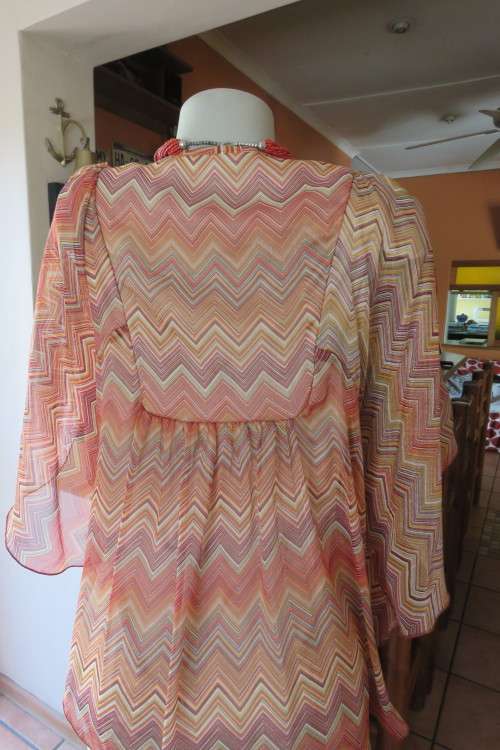 Stunning cream sleeveless polyester top with overlay in zig-zag autumn colours. Size 40/16.