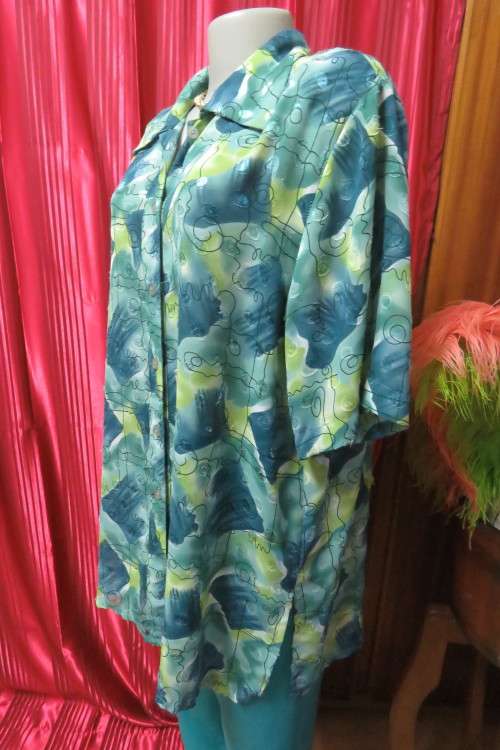 Cheerful summer blouse in medley of greens with black curled lines. Size 44/20.