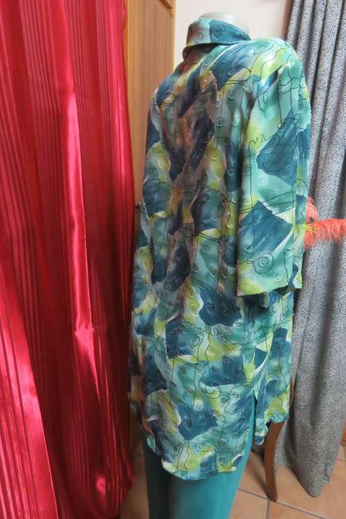 Cheerful summer blouse in medley of greens with black curled lines. Size 44/20.