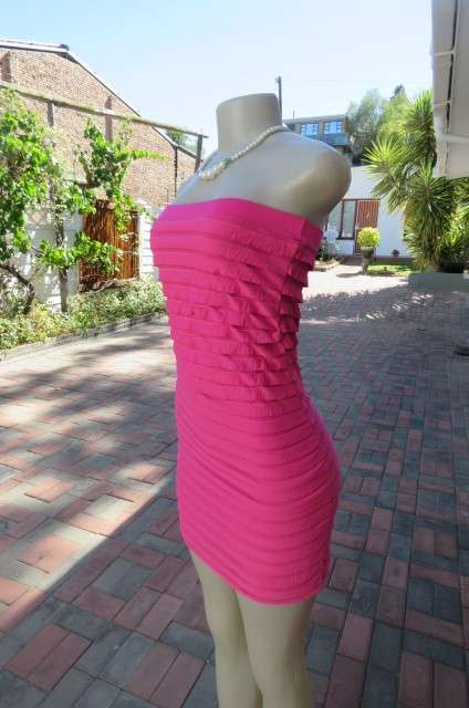 Hot pink bodycon strapless ruffled dress in stretch polyester. Fully lined. Size 32 to 34 clubdress.