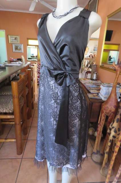 Smart black dress by 'Donna Claire' in size 42/18. Cross over bust with ties.Satin top.