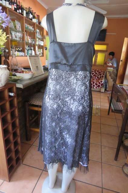 Smart black dress by 'Donna Claire' in size 42/18. Cross over bust with ties.Satin top.