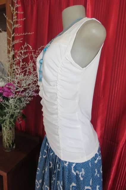 Femininei white top with square sequined neckline. Sleeveless size 36/12.In polyester/nylon.As new