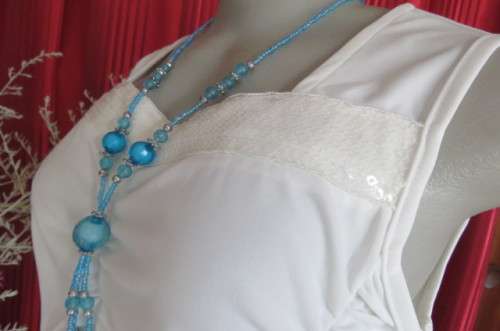 Femininei white top with square sequined neckline. Sleeveless size 36/12.In polyester/nylon.As new
