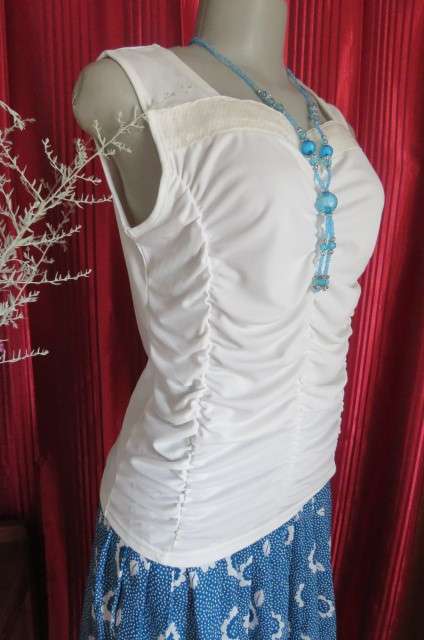Femininei white top with square sequined neckline. Sleeveless size 36/12.In polyester/nylon.As new