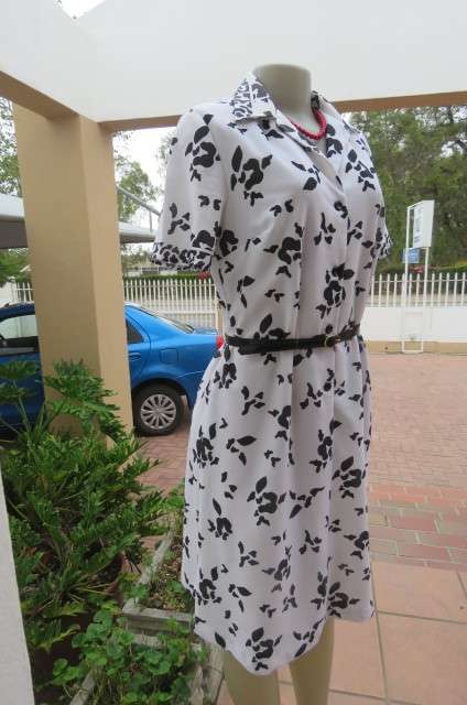 Pretty monochrome shift dress with short sleeves. Partly button down front size 37/13. Open collar.