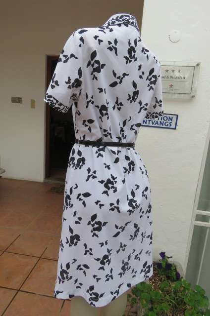 Pretty monochrome shift dress with short sleeves. Partly button down front size 37/13. Open collar.