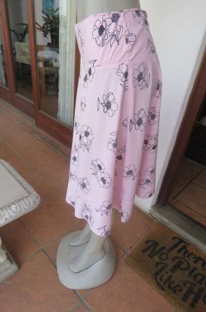Lovely coral colour wide A-line skirt with black flowers.Yoked waist size 34/10 by `Legit`. As new.