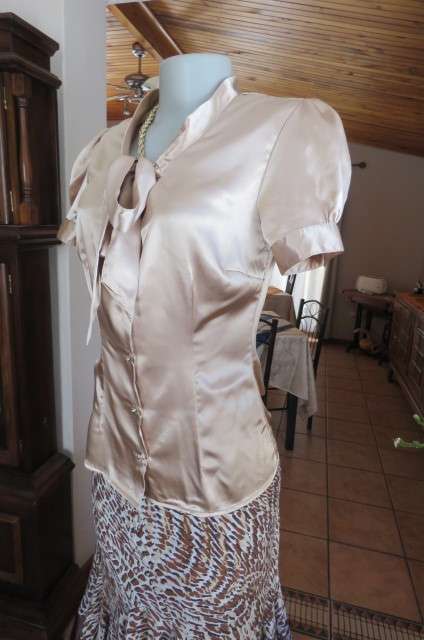Dark cream shiny button down top with tie collar. Stretch polyester size 32/8. Puffed short sleeves.