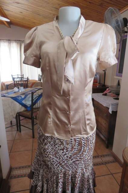 Dark cream shiny button down top with tie collar. Stretch polyester size 32/8. Puffed short sleeves.
