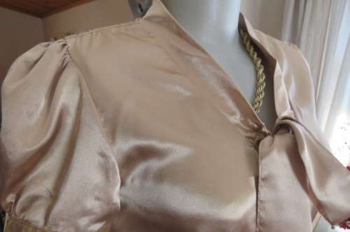 Dark cream shiny button down top with tie collar. Stretch polyester size 32/8. Puffed short sleeves.