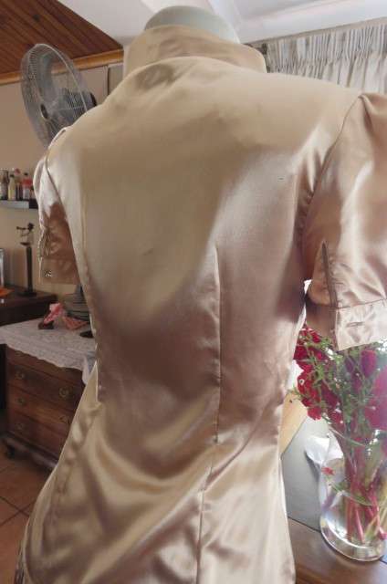 Dark cream shiny button down top with tie collar. Stretch polyester size 32/8. Puffed short sleeves.