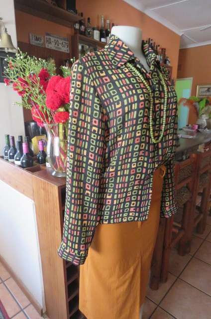 Beautiful black long sleeve polyester top with small green and peach graphic designs size 34/10.
