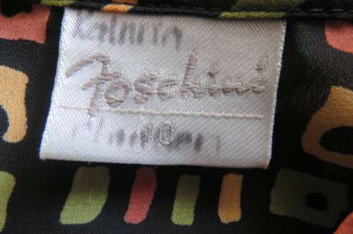 Beautiful black long sleeve polyester top with small green and peach graphic designs size 34/10.