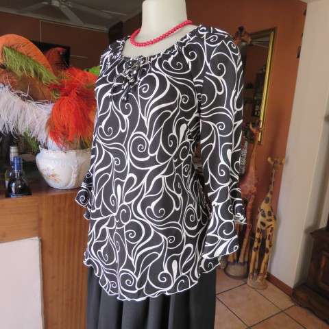 Monochrome top in graphic pattern with tiestring neckline. Size 40/16. In stretch polyester.