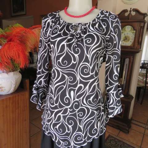 Monochrome top in graphic pattern with tiestring neckline. Size 40/16. In stretch polyester.