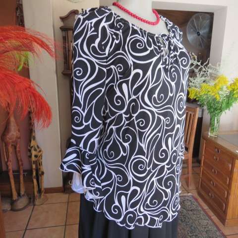 Monochrome top in graphic pattern with tiestring neckline. Size 40/16. In stretch polyester.