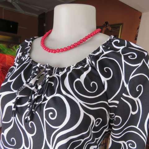 Monochrome top in graphic pattern with tiestring neckline. Size 40/16. In stretch polyester.
