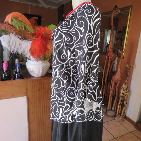 Monochrome top in graphic pattern with tiestring neckline. Size 40/16. In stretch polyester.