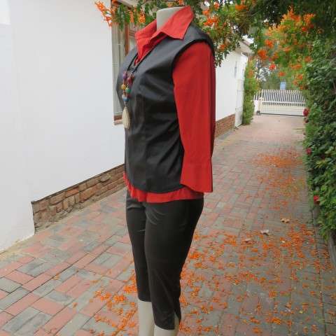 Black shiny pull over V neck ,sleeveless top that resembles vinyl on front. Size 34/10 by BESTS.