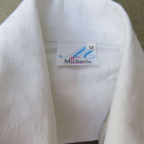Snow white button down top with cuffed bracelet length sleeves.By MICHAELA in size 38/14