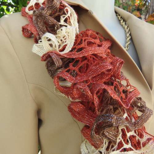 Narrow cotton knit scarf done in ongoing frills. In cream,brick and brown with silver thread. As new