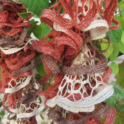 Narrow cotton knit scarf done in ongoing frills. In cream,brick and brown with silver thread. As new