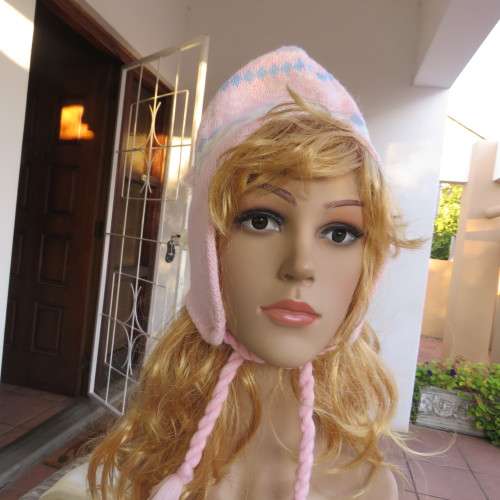 Cosy pink knitted earflap hat with ties. In blue, white pattern. Fleece inner. With pompom.