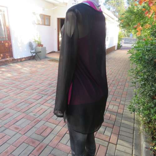 Fabulous sheer black long sleeve top. Slitted sides. Round neckline size 34/10. New condition.