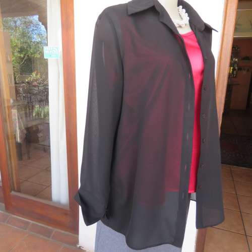 Black sheer polyester long sleeve top with button down front and open collar. Size 36/12 by TOPICS.