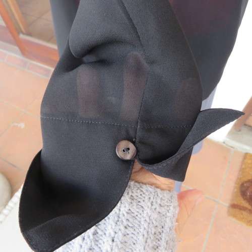 Black sheer polyester long sleeve top with button down front and open collar. Size 36/12 by TOPICS.